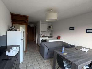 a kitchen and a living room with a couch and a table at Maison calme proche plage et commerces - FR-1-831-13 in Biscarrosse
