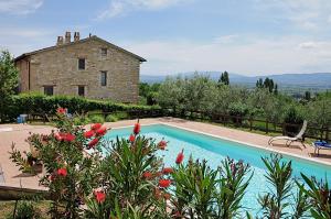 una casa con piscina y un edificio en Villa Rosy en Assisi