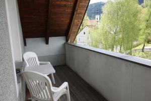 a white chair sitting in front of a window at Hotel-Restaurant Goldenes Schiff in Engelhartszell