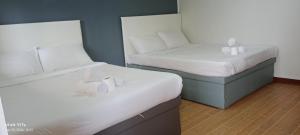 twee eenpersoonsbedden in een kamer met bij The Nice rssort in General Trias