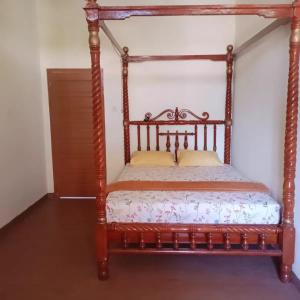a bed in a room with a wooden bed frame at Zhafran homestay syari'ah in Sarilamak +11 photos