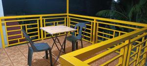 a table and two chairs on a balcony at Bon Joy Bed & Breakfast in Mabini