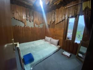 une chambre avec un lit et une fenêtre dans l'établissement Rumah Kayu Tanjakan, à Nempel 6 autres photos