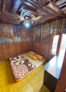 une petite chambre avec un lit dans une pièce en bois dans l'établissement Rumah Kayu Tanjakan, à Nempel