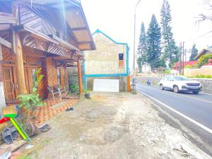 une maison sur le côté d'une rue avec une voiture dans l'établissement Rumah Kayu Tanjakan, à Nempel