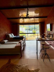 a bedroom with two beds and a large window at Pousada Refúgio das Águas Quarto 4 in Chapecó