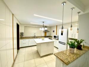 a kitchen with white cabinets and a white refrigerator at Quarto para locação em apartamento in Conselheiro Lafaiete