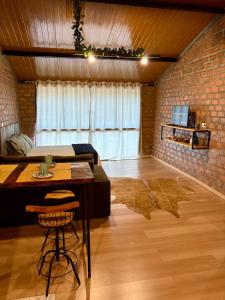 a room with a bed and a table and a brick wall at Pousada Refúgio das Águas Quarto 3 in Chapecó