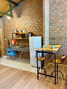 a kitchen with a white refrigerator and a table at Pousada Refúgio das Águas Quarto 3 in Chapecó +4 photos