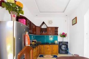 une cuisine avec un réfrigérateur et un micro-ondes dans l'établissement T'Homestay garden villa, à Thôn Lại Thê