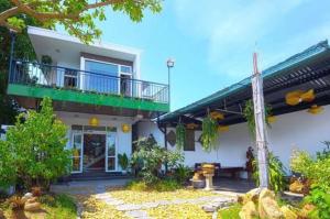 Cette maison blanche dispose d'un balcon et d'une terrasse. dans l'établissement T'Homestay garden villa, à Thôn Lại Thê