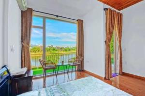 une chambre avec un lit et un balcon avec vue dans l'établissement T'Homestay garden villa, à Thôn Lại Thê