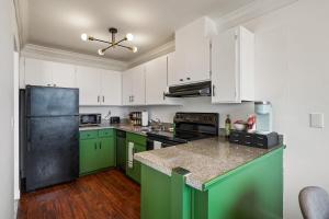 a kitchen with green cabinets and a black refrigerator at Stunning 2BR with Ocean, Mountain & Sunset Views in Pacifica +37 photos