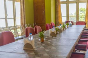 a long table in a room with red chairs at Divyaraa Breathing Stone in Kalimpong