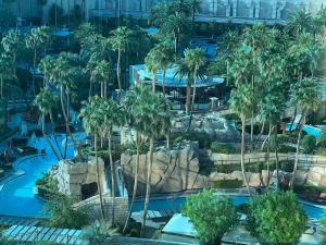 an aerial view of a resort pool with palm trees at MGM Signature - NO FEEs, Free Valet, Lazy river View in Las Vegas