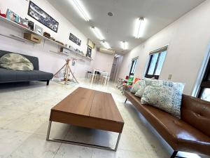 a living room with a couch and a coffee table at TRIANGLEosaka in Osaka
