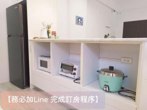 una cucina con bancone, forno a microonde e frigorifero di 荷風緩緩包棟民宿 a Jiaoxi
