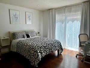 a bedroom with a black and white bed and a window at Spacious Home Steps from Huge Park and Outdoor Fun in San Jose