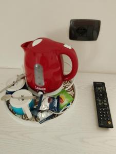 a red tea pot sitting on a table next to a remote control at Ca' del Golfo in Levanto