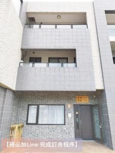 un alto edificio con balcone e porta di 荷風緩緩包棟民宿 a Jiaoxi