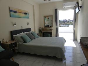 a bedroom with a bed and a sliding glass door at AMZ Apartments in Kato Gouves