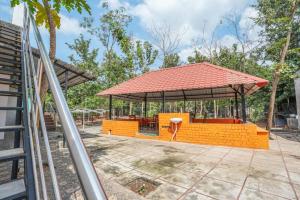a large orange pavilion with a table and chairs at GreenWoods Farm House in Puducherry