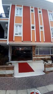a red building with a red rug in front of it at Volkii Otel1 in Antalya