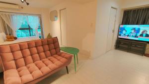 a living room with a couch and a flat screen tv at Stunning luxury APT with balcony in Tokyo Shinjuku Kabukicho in Tokyo