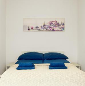 a bed with blue pillows on top of it at Toscany de LUX samo centrum in Bielsko-Biała