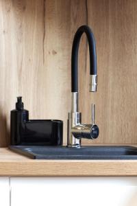 a kitchen sink with a black faucet on a counter at Toscany de LUX samo centrum in Bielsko-Biała +19 photos