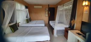 a small room with two beds and a tv at Cookies Salad Resort in Salad Beach