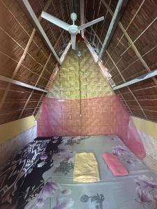 a ceiling fan in a room with a bed at Destiny Rainbow Beach Resort in Siquijor