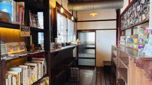 a book store with books on shelves and a counter at 古民家ゲストハウス ナマケモノ in Ōno