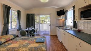 una cucina e un soggiorno con letto e tavolo di Gday Parks Emerald a Emerald