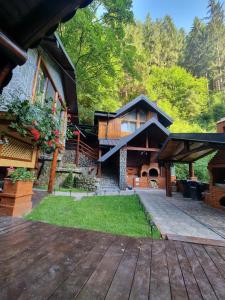 an exterior view of a house with a wooden deck at Căbănuța Cocoțată in Rucăr