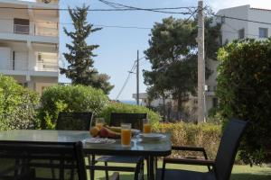 Palm & Pearl Apartment في أثينا: طاولة عليها فاكهة وعصير برتقال