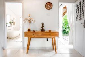 Moon & Honey villa في أوبود: مكتب في الحمام مع حوض استحمام وساعة