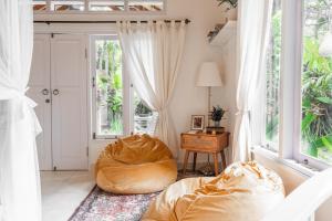 Moon & Honey villa في أوبود: غرفة معيشة مع كرسي كيس فول ونافذة
