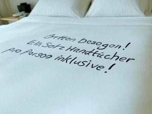 eine Schrift auf der Seite eines weißen Bettes in der Unterkunft Haus Elbe -Wohnung 14- Zentral in Döse in Cuxhaven