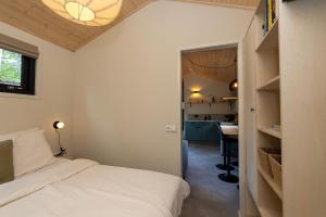 a small bedroom with a bed and a kitchen at Boswilg in Zuidwolde
