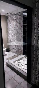 a bathroom with a shower with a toilet in it at Bokmakierie in Centurion