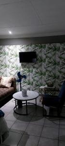 a room with a couch and a table in front of a wall at Bokmakierie in Centurion +11 photos