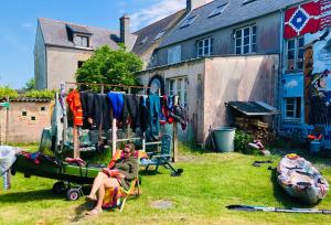 ein paar Leute sitzen auf einem Stuhl in einem Hof in der Unterkunft Auberge du Lama Zébré in Penmarcʼh + 13 Fotos