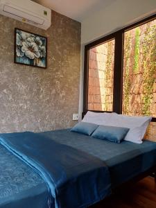 ein Bett mit zwei Kissen in einem Zimmer mit einem Fenster in der Unterkunft Boom Casa Homestay in Hue