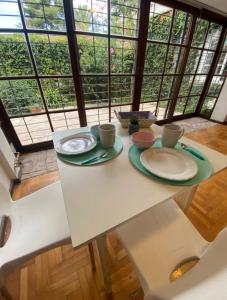 una mesa blanca con platos y tazas. en Casa Bella Mendoza, en Mendoza