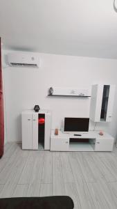 a white living room with a tv and a table at Apartament pe pietonala nr1 in Hunedoara