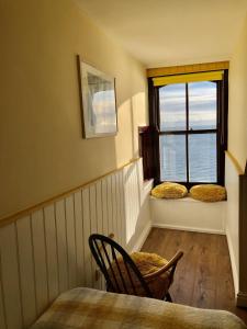 a room with a table and two chairs and a window at No: 1 The Esplanade Guest Accommodation. in Tenby