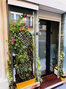 una puerta abierta con flores rosas en un edificio en Amber Apartment Nice - Central Highlights and Beach, en Niza