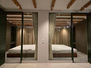 a bedroom with two beds and two mirrors at The Ten Poolvilla Huahin in Hua Hin