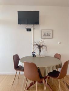 a dining room table with chairs and a tv on a wall at Prizba Tomas in Blato